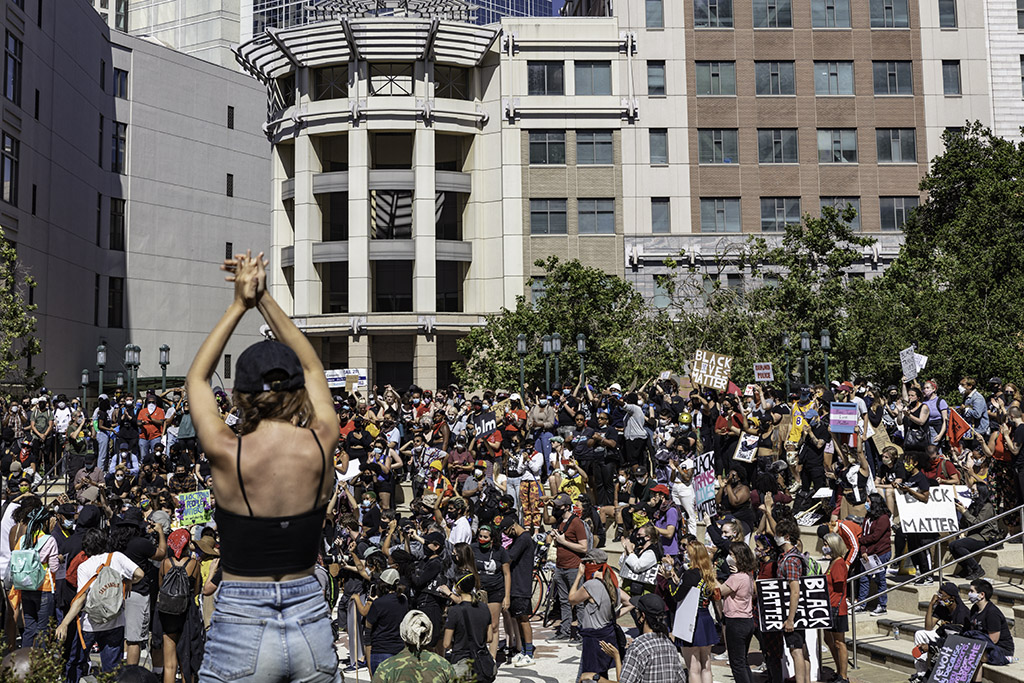protestors applaud a speaker at downtown Oakland's Juneteenth  2020 protest