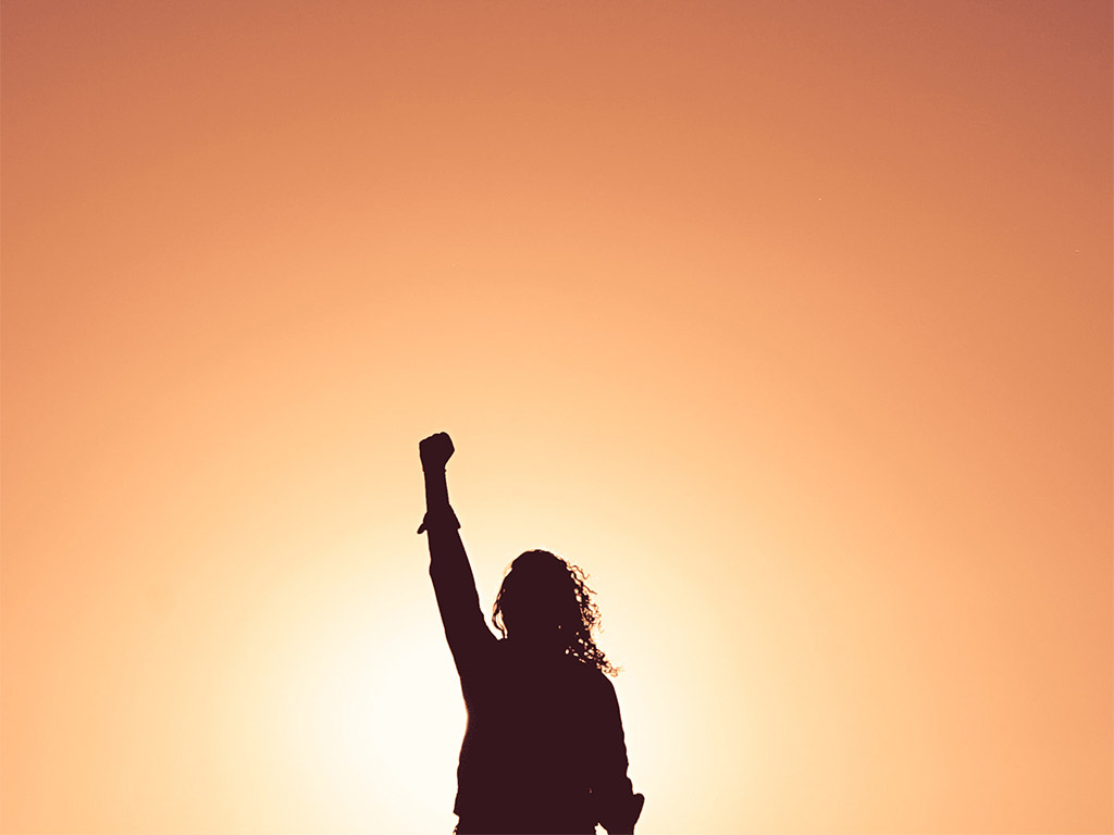 silhouette of a woman with her fist in the air