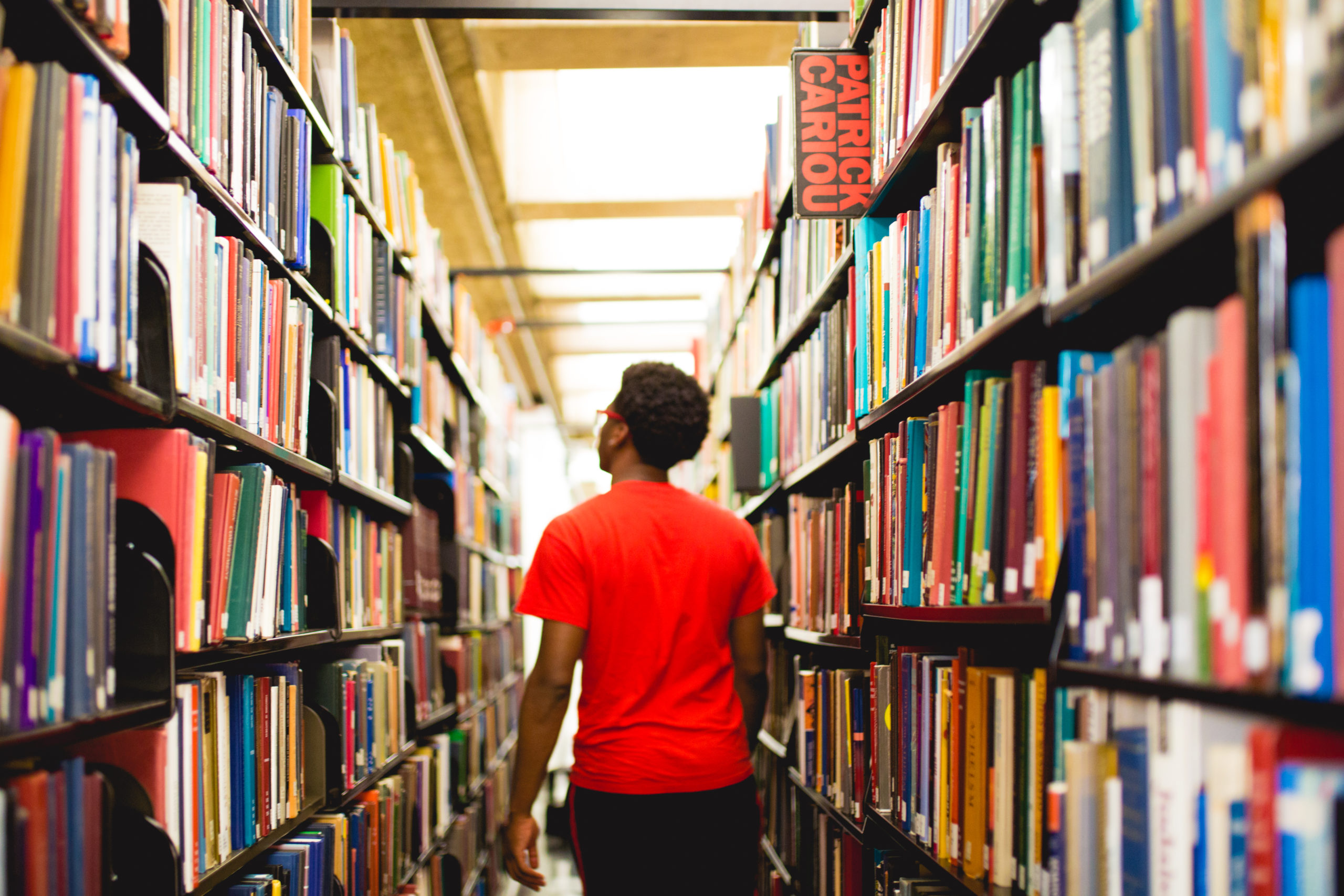 student-walking-through-college-library